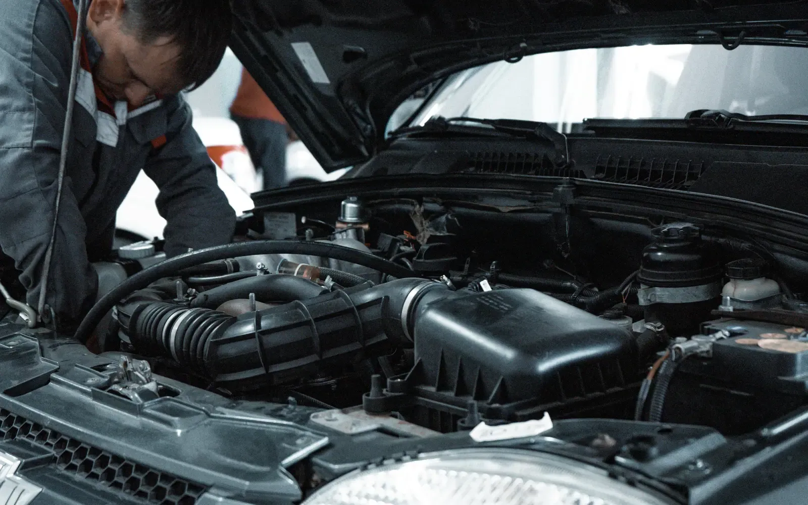Mechanic inspecting a car engine in an auto repair shop